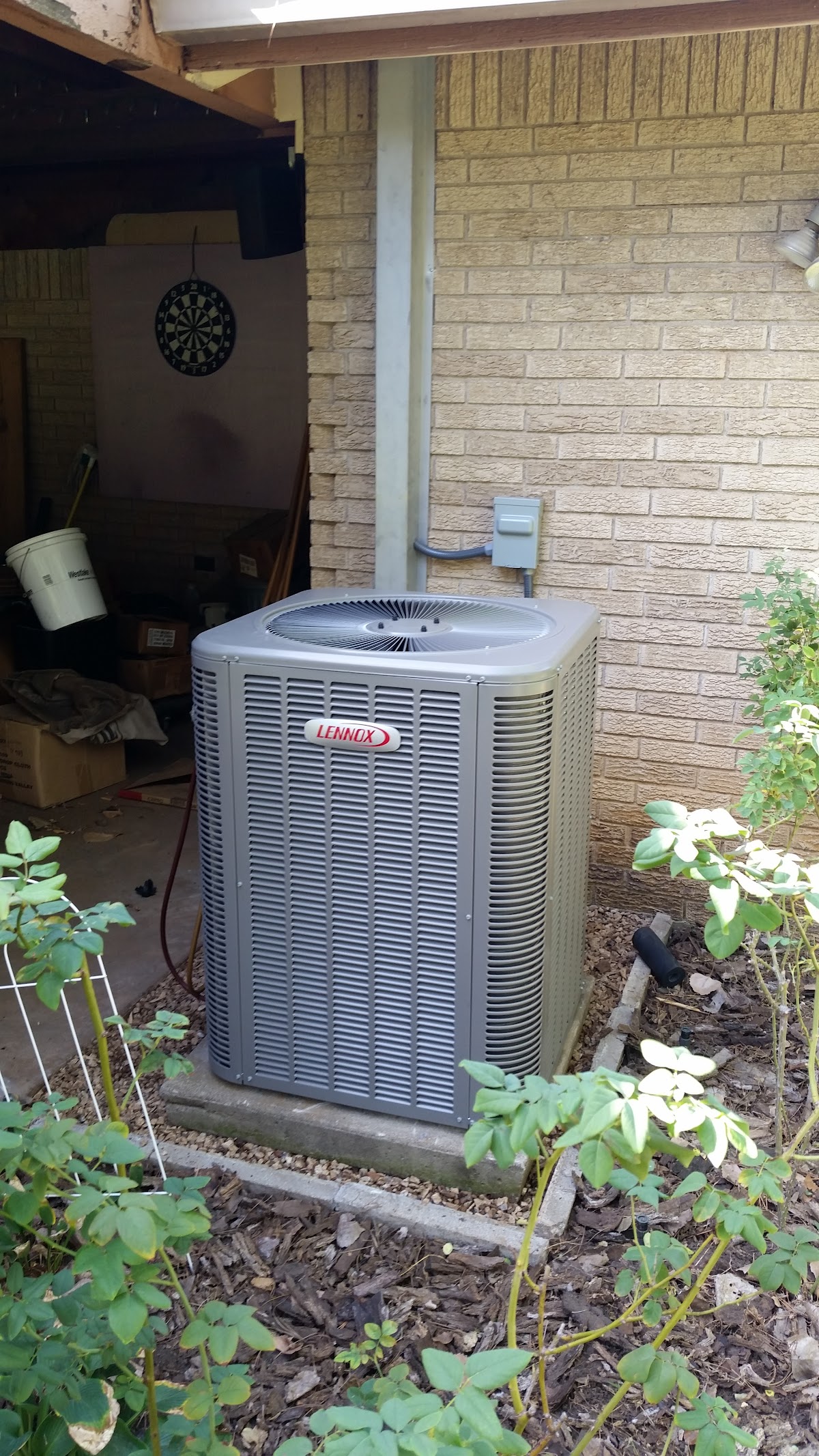 Outdoor Lennox air conditioning unit installed beside a brick home